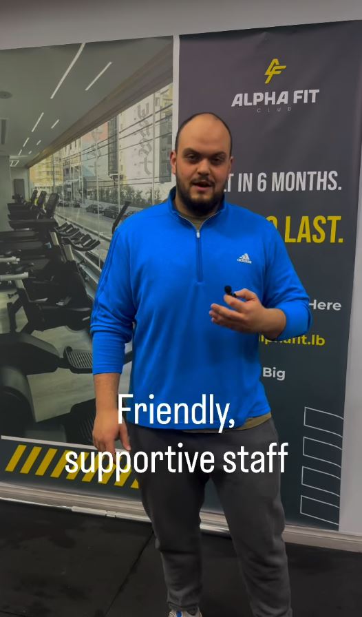 Alpha Fit Club coach at the gym entrance